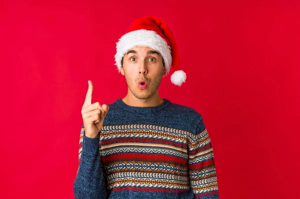 Молодий Чоловік Різдвяний День Здивований Вказуючи Пальцем Посміхаючись Широко — стокове фото