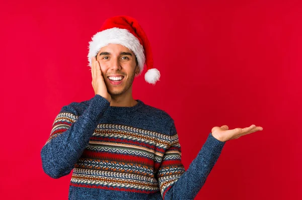 Молодий Чоловік Різдвяний День Посміхається Вказує Вбік Показуючи Щось Порожньому — стокове фото