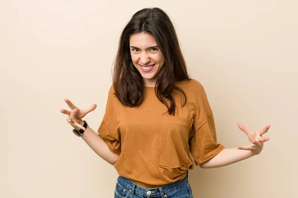 Jong Brunette Vrouw Tegen Een Beige Achtergrond Schreeuwen Met Woede — Stockfoto