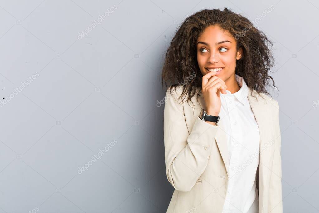 Young african american business woman relaxed thinking about something looking at a copy space.