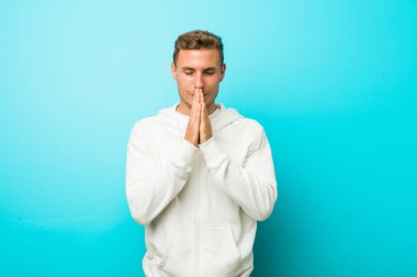 Genç kafkas spor adam ağız yakınında dua el ele tutuşuyor, kendinden emin hissediyor.