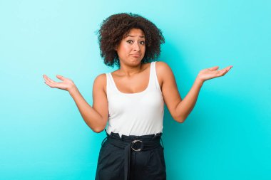 Genç Afro-Amerikalı kadın şüphe ediyor ve omuz silkiyor..