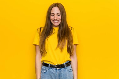 Kızıl saçlı genç kadın gülüyor ve gözlerini kapıyor, rahatlamış ve mutlu hissediyor..