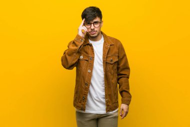 Genç İspanyol rahat adam parmak ile tapınak işaret, düşünme, bir görev üzerinde duruldu.