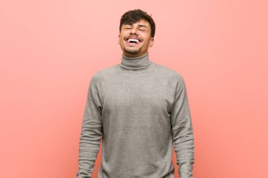 Genç ve zeki bir öğrenci rahatlamış ve mutlu gülüyor, boynunu uzatmış dişlerini gösteriyor..