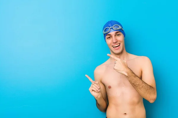 Νεαρός Κολυμβητής Δείχνει Μπροστινά Δάχτυλα Ένα Χώρο Αντιγραφής Εκφράζοντας Ενθουσιασμό — Φωτογραφία Αρχείου