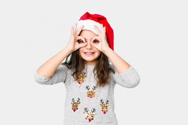 Dziewczynka Świętuje Boże Narodzenie Pokazując Znak Okay Nad Oczami — Zdjęcie stockowe