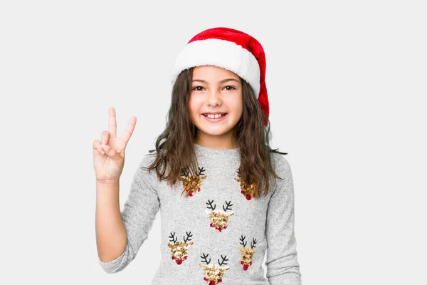 Маленька Дівчинка Святкує Різдвяний День Показуючи Знак Перемоги Посміхаючись Широко — стокове фото