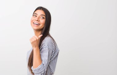 Genç, güzel bir Arap kadını başparmağıyla işaret ediyor, gülüyor ve kaygısız.