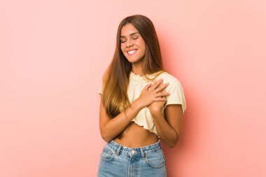 Genç, sıska bir kadın gülüyor. Elini yüreğine koyuyor. Mutluluk kavramı..