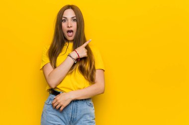 Genç kızıl saçlı kadın yan tarafı işaret ediyor.