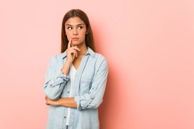 Sıska bir kadın şüpheli ve şüpheci bir ifadeyle yana bakıyor..