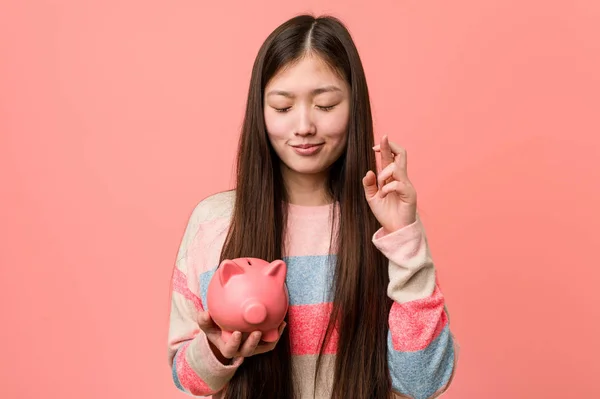 Ung Asiatisk Kvinna Håller Spargris Korsning Fingrar För Att Tur — Stockfoto