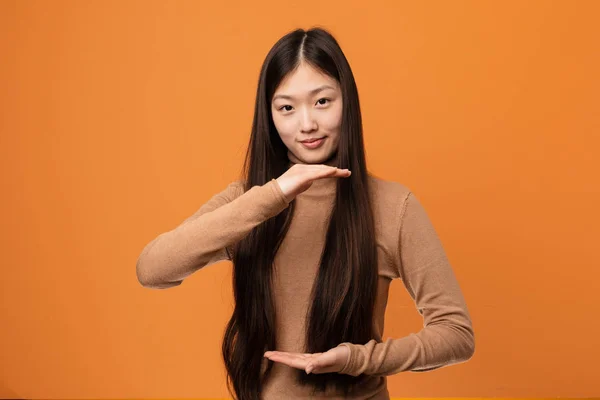 Joven Mujer Bastante China Sosteniendo Algo Con Ambas Manos Presentación —  Fotos de Stock