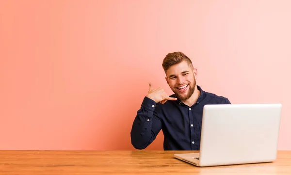 Joven Trabajando Con Portátil Mostrando Gesto Llamada Teléfono Móvil Con — Foto de Stock