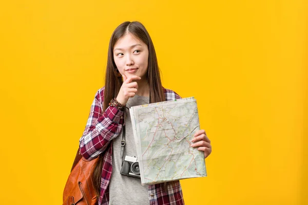 Young Asian Woman Holding Map Looking Sideways Doubtful Skeptical Expression — Stock Photo, Image