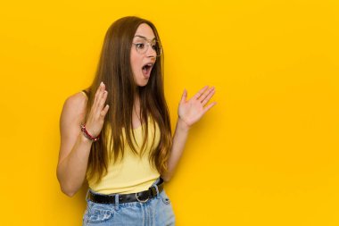 Kızıl saçlı genç kadın çilli bağırıyor, gözleri açık ve elleri gergin..