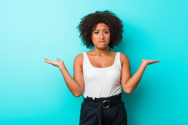 Genç Afrikalı Amerikalı kadının kafası karışık ve omuz silkiyor..
