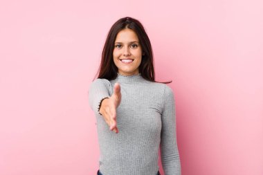 Genç, tatlı bir kadın kameraya elini uzatıp selam veriyor..