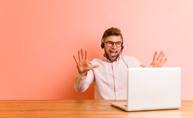 Çağrı merkezinde çalışan genç adam 10 numarayı elleriyle gösteriyor..