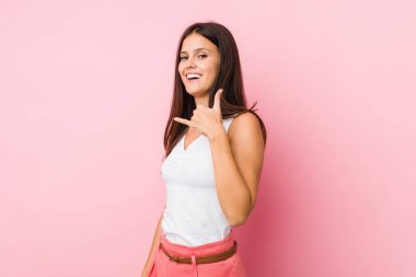 Genç ve güzel bir kadın cep telefonu hareketini parmaklarıyla gösteriyor..