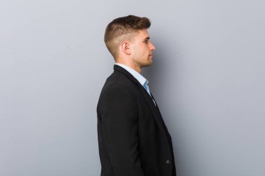 Genç, yakışıklı, beyaz bir adam sola bakıyor..