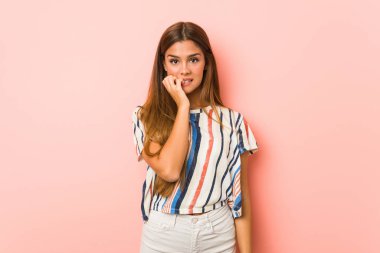 Tırnak yiyen genç, sıska bir kadın, gergin ve çok endişeli..