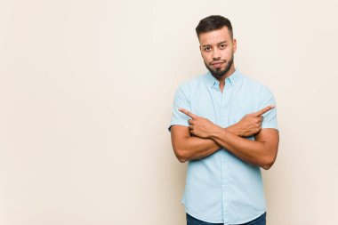 Güney Asyalı genç adam iki seçenek arasında seçim yapmaya çalışıyor..