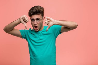 Kafkasyalı genç adam baş parmağını aşağı gösteriyor ve hoşlanmadığını ifade ediyor..