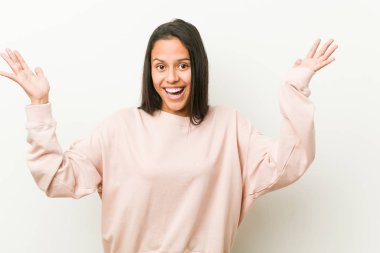 Genç, tatlı İspanyol genç kadın hoş bir sürprizle karşılaşıyor, heyecanlı ve el kaldırıyor..