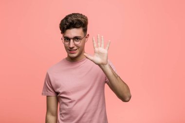 Young cool caucasian man smiling cheerful showing number five with fingers.
