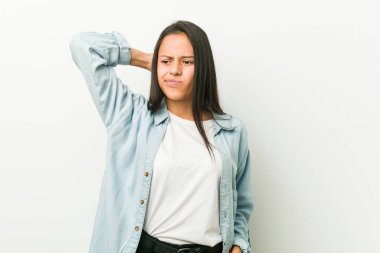 Genç İspanyol kadın başının arkasına dokunuyor, düşünüyor ve bir seçim yapıyor..