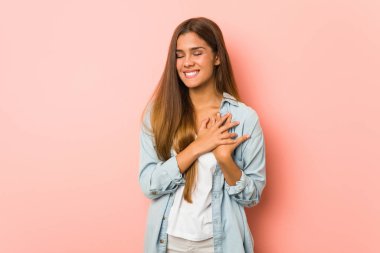 Genç, sıska bir kadın gülüyor. Elini yüreğine koyuyor. Mutluluk kavramı..