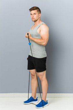 Genç fitness kafkas adam elastik bir bant ile pratik.