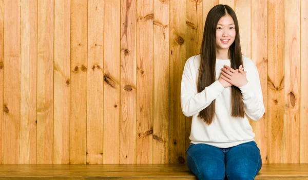Mulher Chinesa Jovem Sentado Lugar Madeira Tem Expressão Amigável Pressionando — Fotografia de Stock
