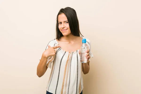 Молодая Латиноамериканка Держащая Бутылку Водой Указывая Пальцем Тебя Словно Приглашая — стоковое фото