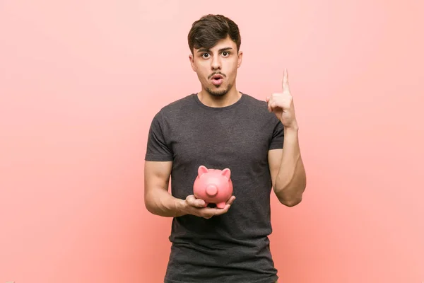 Jovem Hispânico Homem Segurando Porquinho Banco Ter Alguma Grande Ideia — Fotografia de Stock