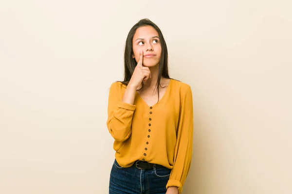 Young Hispanic Woman Beige Background Looking Sideways Doubtful Skeptical Expression — 图库照片