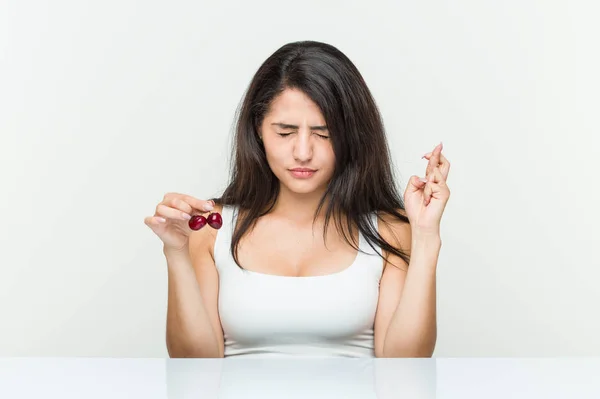 Mujer Hispana Joven Sosteniendo Cerezas Cruzando Dedos Para Tener Suerte —  Fotos de Stock