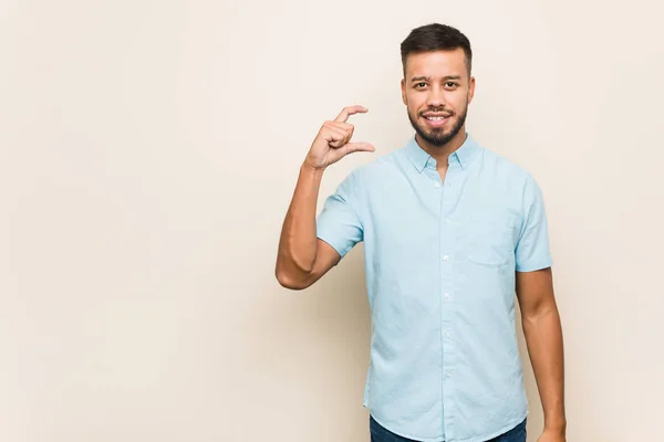 Young South Asian Man Holding Something Little Forefingers Smiling Confident — Stock Photo, Image