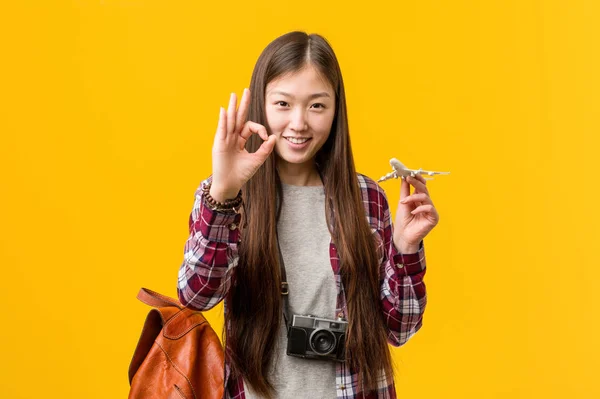 Jovem Asiático Mulher Segurando Avião Ícone Alegre Confiante Mostrando Gesto — Fotografia de Stock