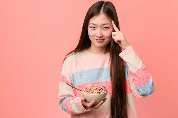 Jonge Aziatische Vrouw Met Een Cornflakes Kom Wijzen Zijn Tempel — Stockfoto