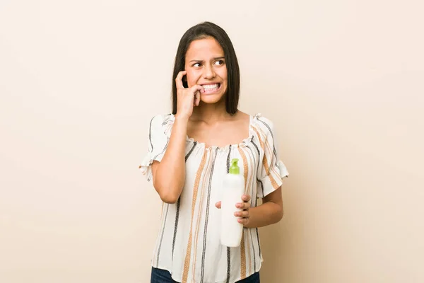 Junge Hispanische Frau Hält Eine Cremeflasche Den Fingernägeln Nervös Und — Stockfoto