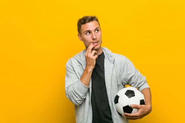 Giovane Uomo Caucasico Possesso Pallone Calcio Rilassato Pensando Qualcosa Guardando — Foto Stock