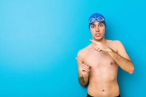 Jovem Nadador Chocado Apontando Com Dedos Indicadores Para Espaço Cópia — Fotografia de Stock