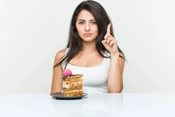 Giovane Donna Ispanica Mangiare Una Torta Mostrando Numero Uno Con — Foto Stock