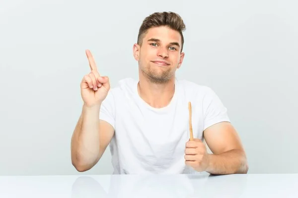 Young Man Holding Toothbrush Showing Number One Finger — Stock Photo, Image