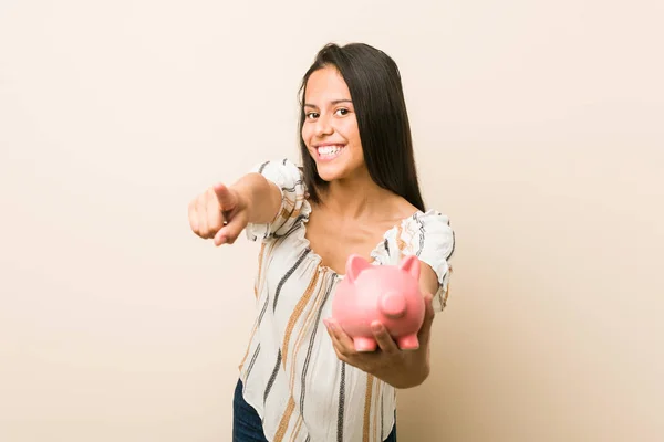 Jovem Hispânica Segurando Banco Porquinho Sorrisos Alegres Apontando Para Frente — Fotografia de Stock