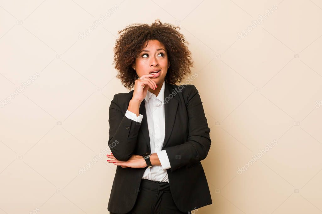 Young business african american woman relaxed thinking about something looking at a copy space.