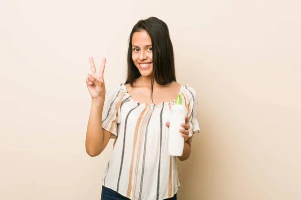 Junge Hispanische Frau Mit Einer Cremeflasche Auf Der Die Nummer — Stockfoto